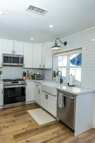 a kitchen with stainless steel appliances granite countertop a stove a sink and a microwave