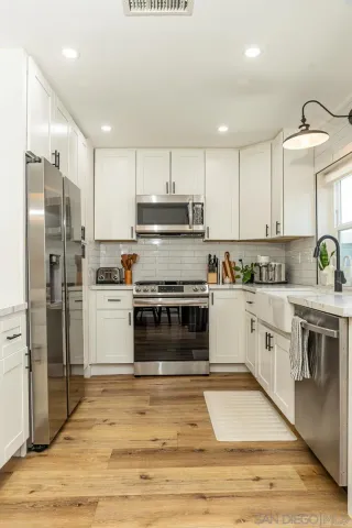 a kitchen with stainless steel appliances and white cabinets