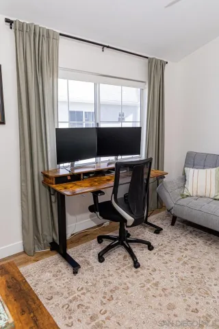a view of a workspace with furniture and a window