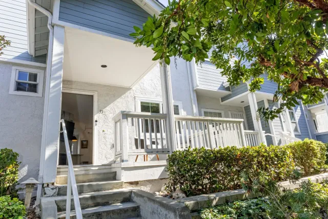 a front view of a house with a tree