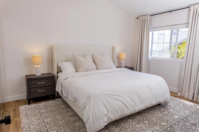 a bedroom with a bed and two windows