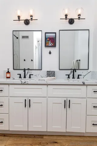 a bathroom with double vanity sinks and a mirror