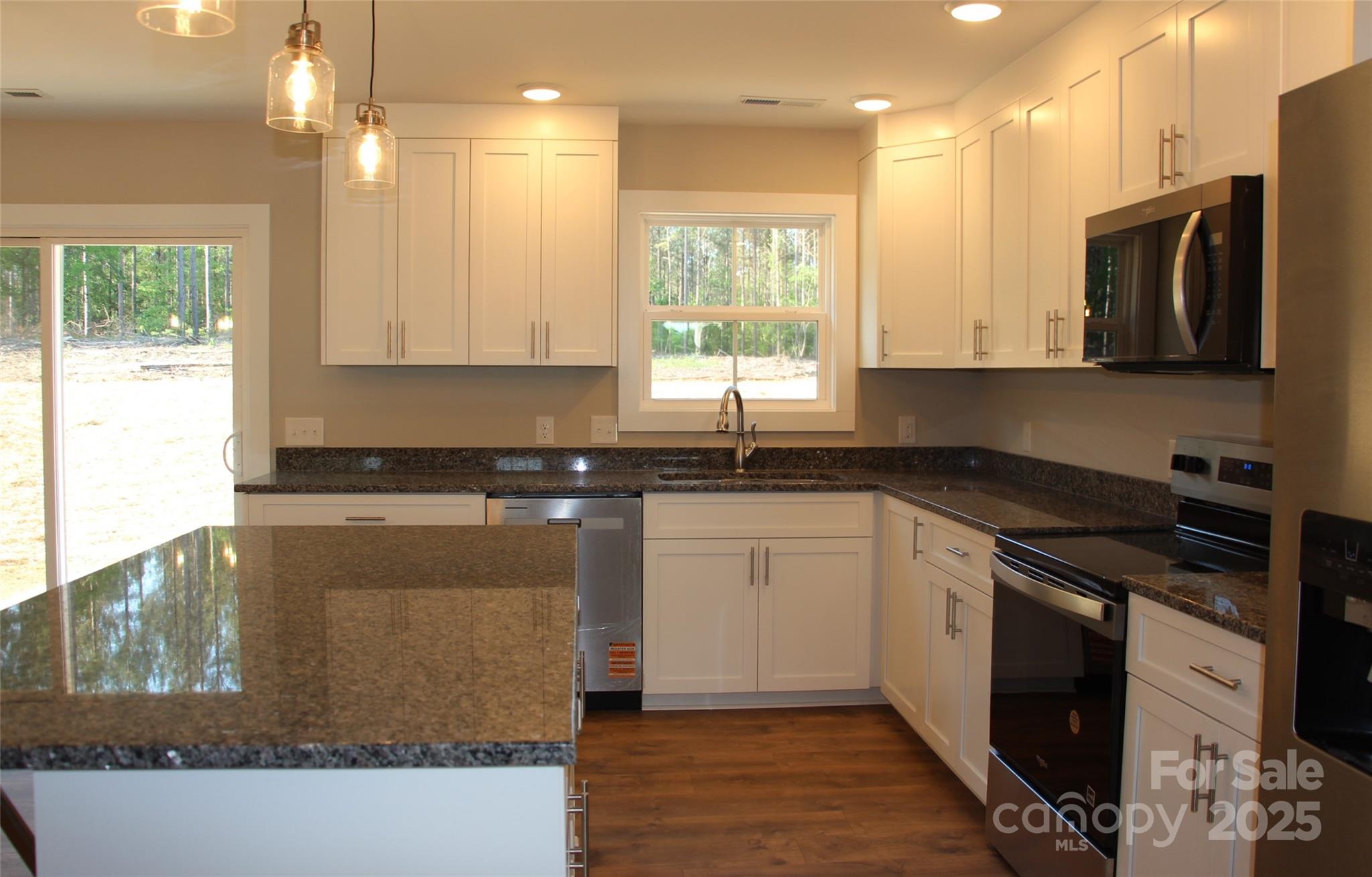 4304 Fletcher Funderburk Road Lancaster, SC 29720 - Photo 8 of 18 a kitchen with granite countertop a stove a sink and a microwave