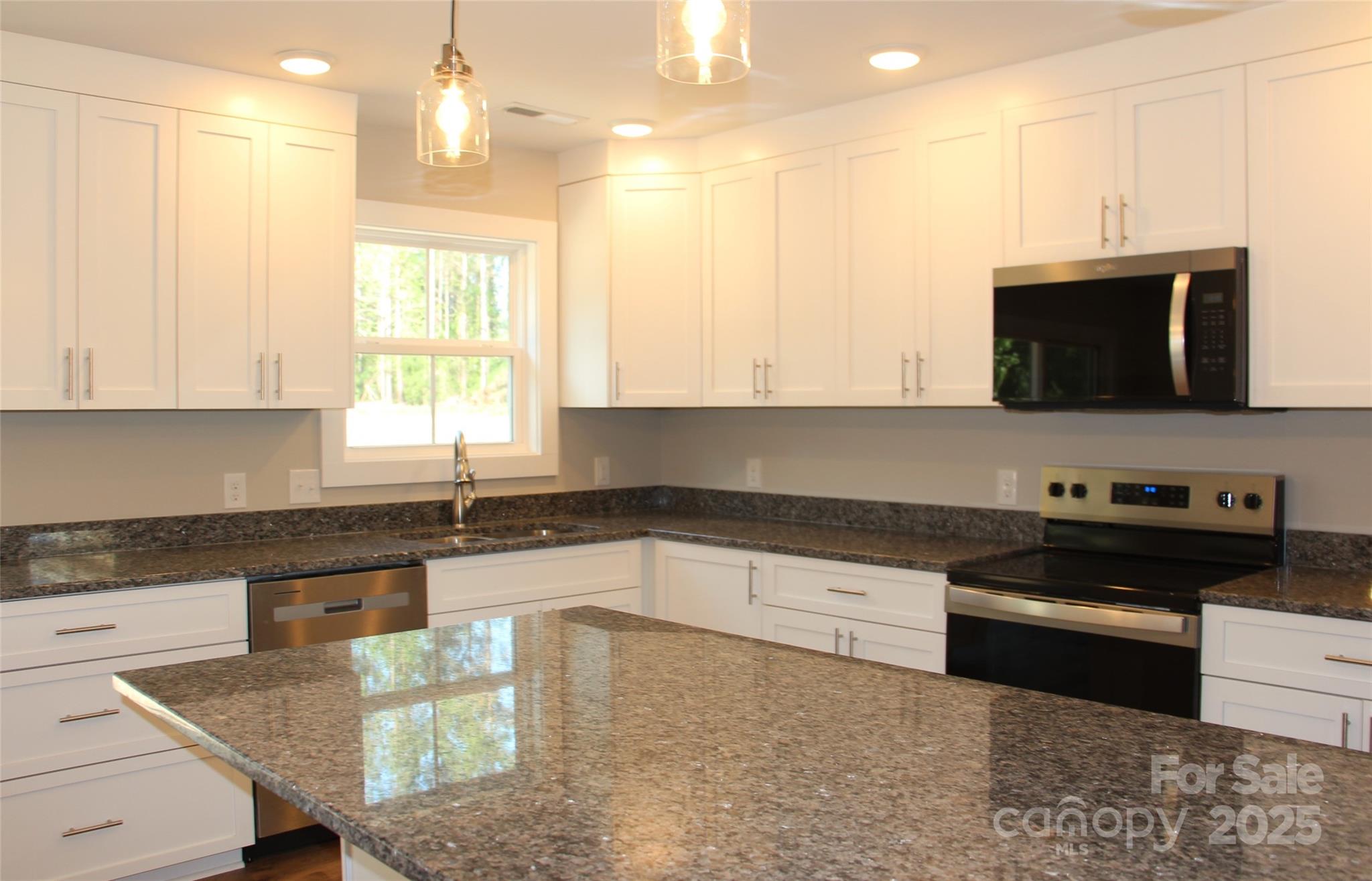 4304 Fletcher Funderburk Road Lancaster, SC 29720 - Photo 9 of 18 a kitchen with stainless steel appliances granite countertop a stove a sink and a microwave