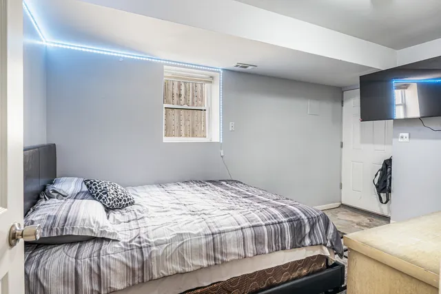 a bedroom with a bed and wooden floor
