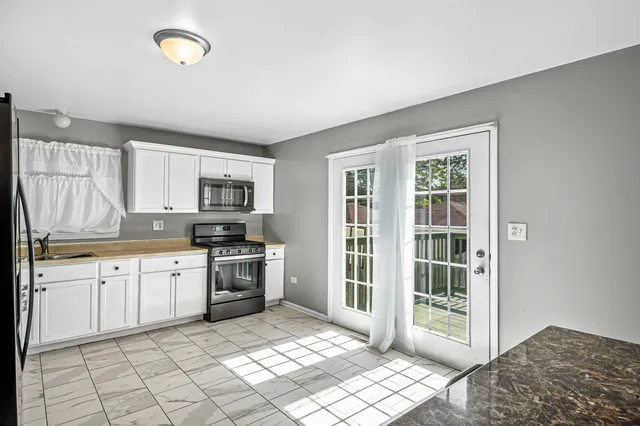 a open kitchen with granite countertop a stove top oven sink and cabinets