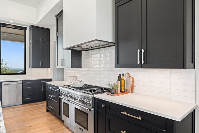 a kitchen with stainless steel appliances a sink stove and cabinets