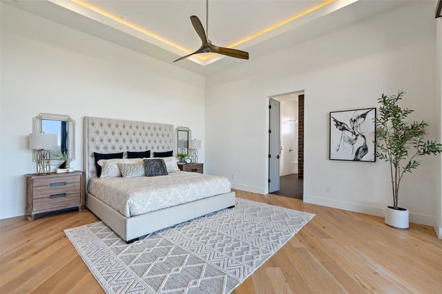 a bedroom with a large bed and a chandelier