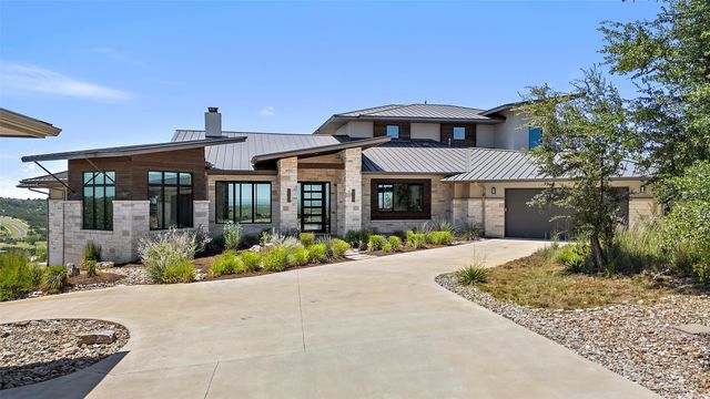 a front view of a house with a yard and potted plants
