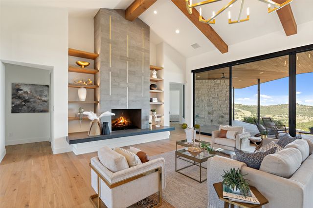 a living room with furniture fireplace and a large window