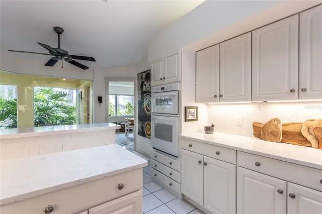 a kitchen filled with white cabinets and white appliances