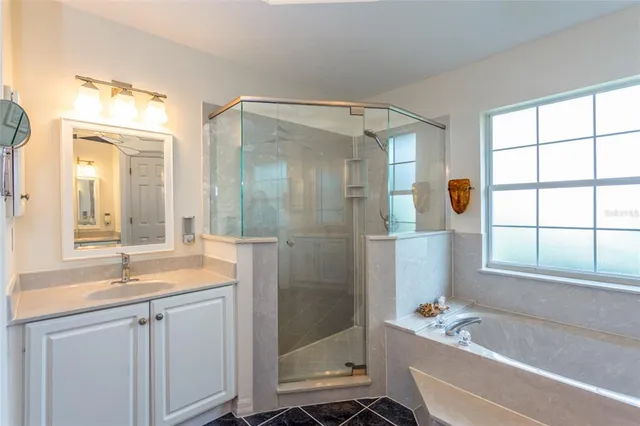 a bathroom with a tub sink shower and mirror