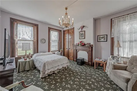 a bedroom with a bed and a flat tv screen on dresser