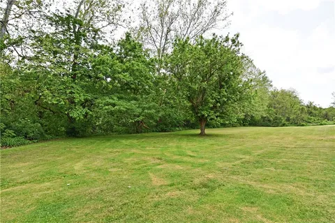 a view of a green field with wooden fence