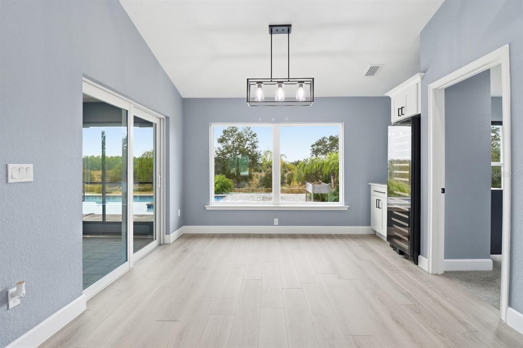 18459 Southwest 66th Loop Dunnellon, FL 34432 - Photo 13 of 41 an empty room with wooden floor a chandelier and windows