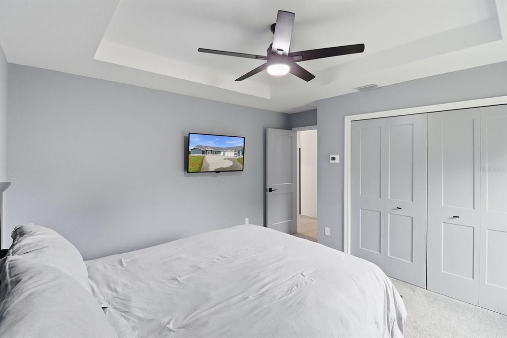 18459 Southwest 66th Loop Dunnellon, FL 34432 - Photo 23 of 41 a bedroom with a large bed and a chandelier