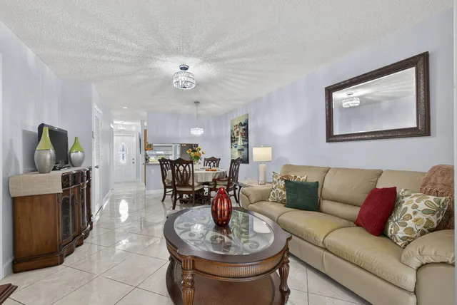 a living room with furniture and a view of kitchen