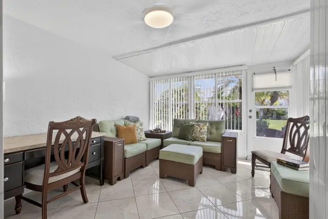 a living room with furniture and a floor to ceiling window