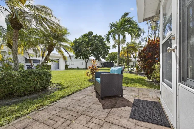 a view of a house with backyard and sitting area