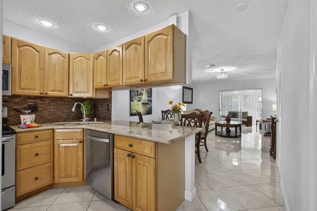 a kitchen with stainless steel appliances a refrigerator sink and microwave