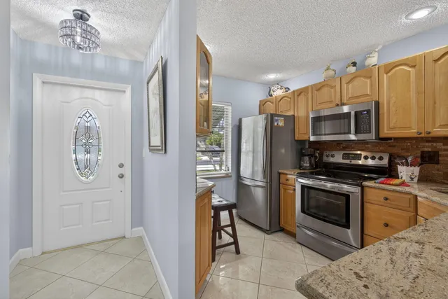 a kitchen with stainless steel appliances a stove a sink a refrigerator a window and cabinets