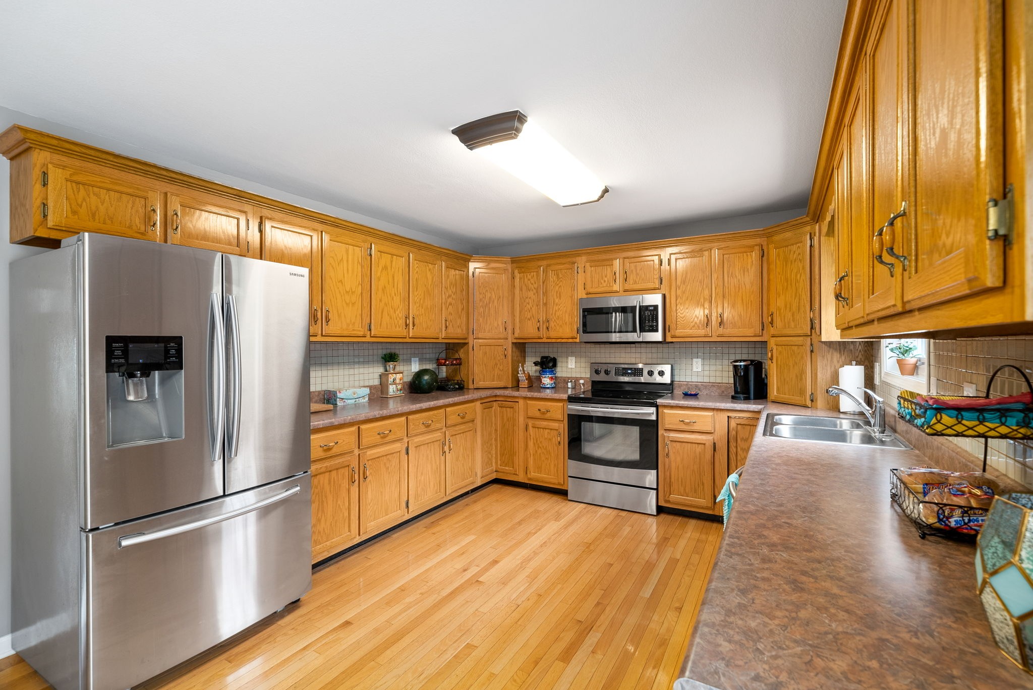 265 Sara Drive Tennessee Ridge, TN 37178 - Photo 15 of 39 a kitchen with stainless steel appliances granite countertop a refrigerator a stove top oven a sink and dishwasher with wooden floor