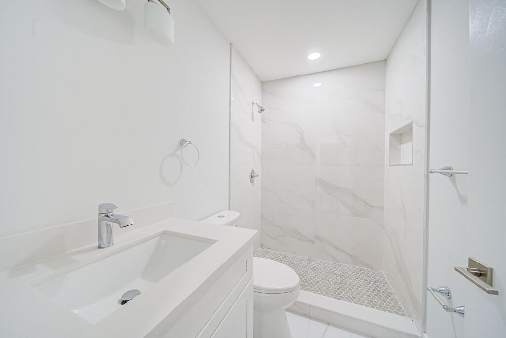 8067 Summerbreeze Lane Boca Raton, FL 33496 - Photo 19 of 29 a bathroom with a sink a toilet and shower