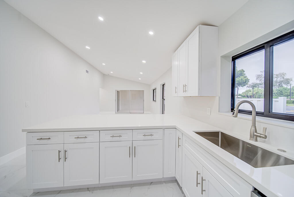 8067 Summerbreeze Lane Boca Raton, FL 33496 - Photo 7 of 29 a kitchen with white cabinets and sink