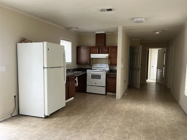 a view of kitchen with refrigerator cabinets and wooden floor