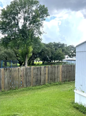 a view of a yard with a fence and trees