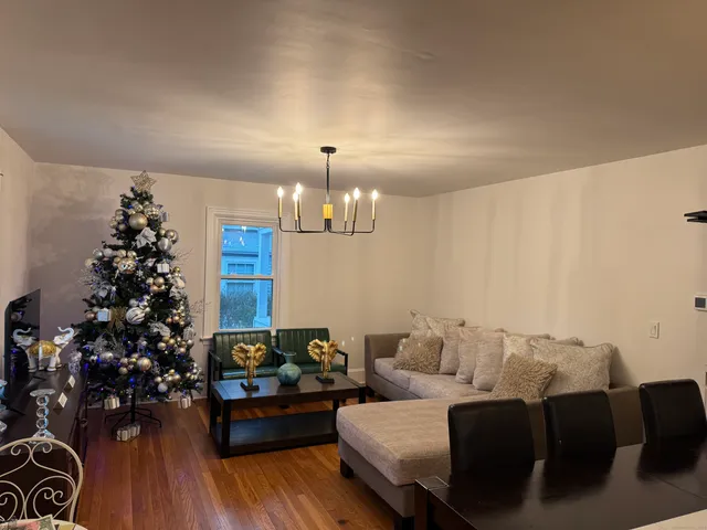 a living room with furniture flowers and a chandelier