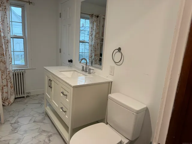 a bathroom with a toilet sink and mirror