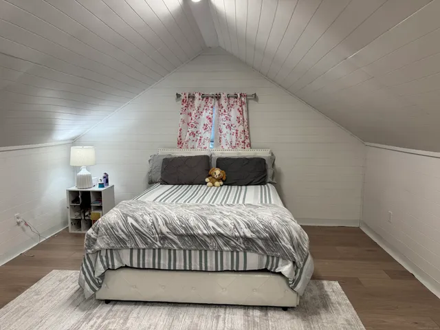 a bedroom with a bed and painting on the wall
