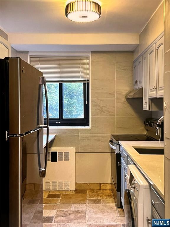 90 Prospect Avenue, Unit 2B Hackensack, NJ 07601 - Photo 4 of 15 a view of a kitchen with a sink and a refrigerator