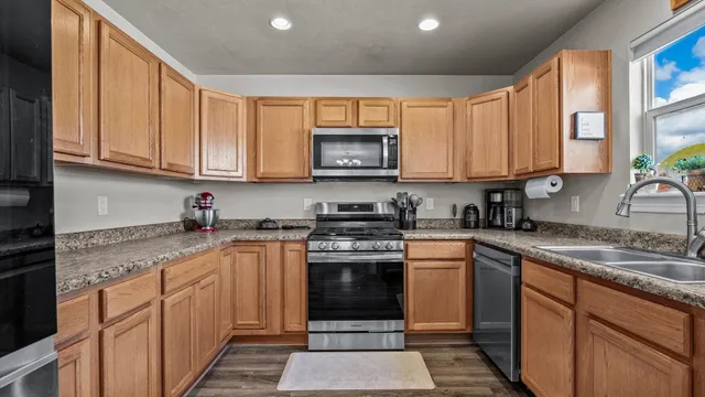 a kitchen with stainless steel appliances granite countertop a stove sink and cabinets