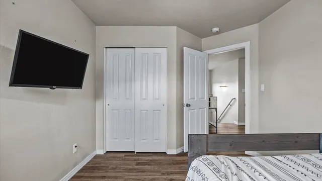 a view of bedroom with wooden floor and flat screen tv