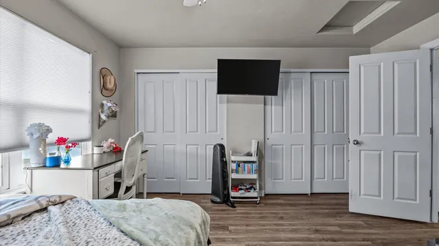 a bedroom with bed and flat tv screen