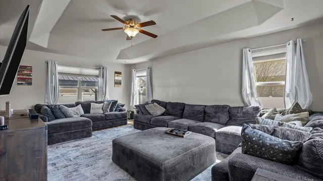 a living room with furniture ceiling fan and a window