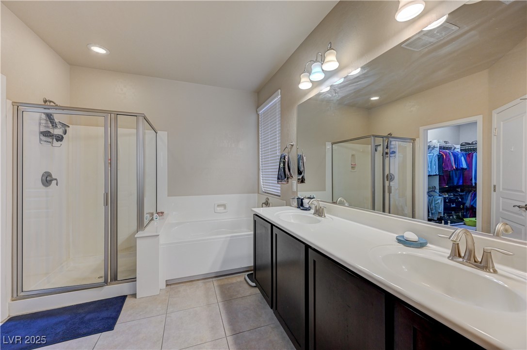 6970 Motley Road Las Vegas, NV 89178 - Photo 26 of 52 Master Bathroom featuring a garden tub and separate stall shower, ceramic tile flooring, and double vanity