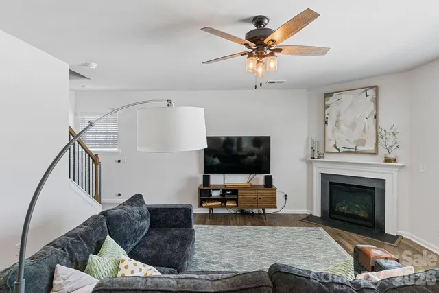 a living room with furniture a fireplace and a flat screen tv