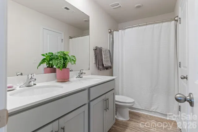 a bathroom with a granite countertop sink a toilet and a mirror