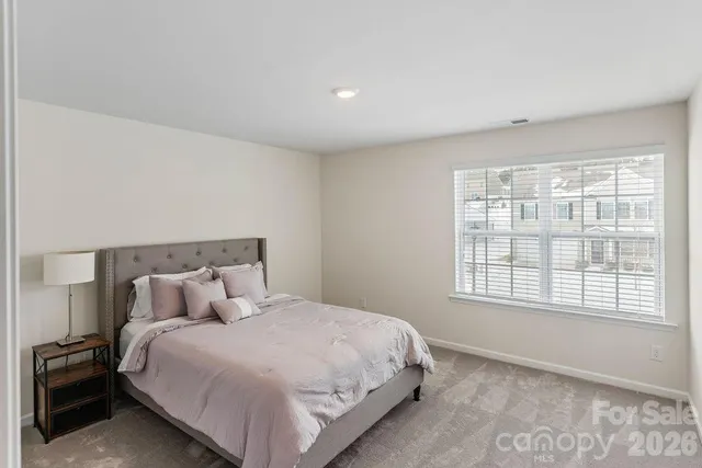 a large bed sitting in a bedroom next to a window