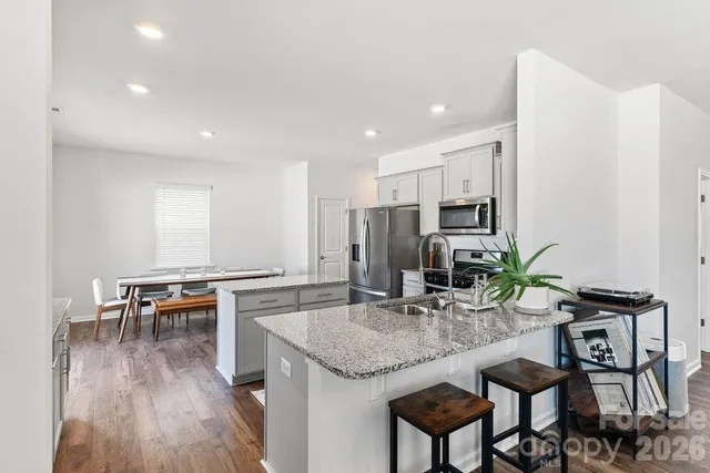 a kitchen with granite countertop kitchen island stainless steel appliances a sink and counter space