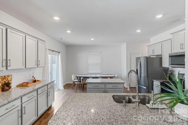 a kitchen with sink refrigerator and microwave