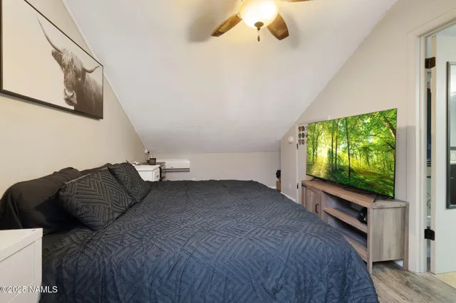 a bedroom with a bed window and flat screen tv
