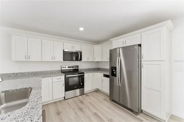 a kitchen with stainless steel appliances granite countertop a refrigerator stove and sink