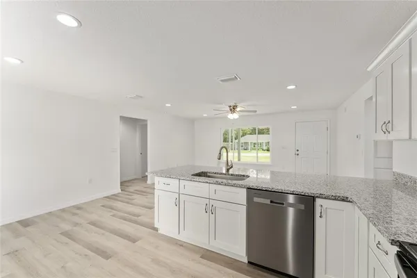 a kitchen with granite countertop cabinets stainless steel appliances a sink and a window