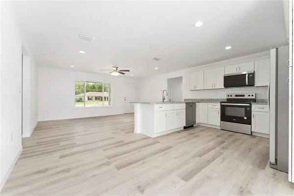 a view of kitchen with microwave and cabinets