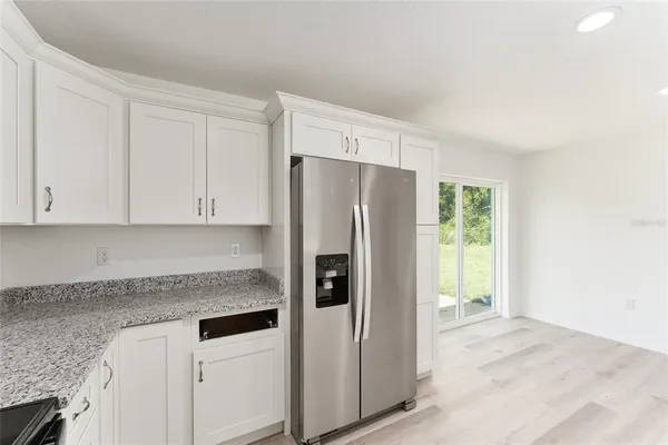 a kitchen with stainless steel appliances granite countertop a refrigerator and a granite counter tops