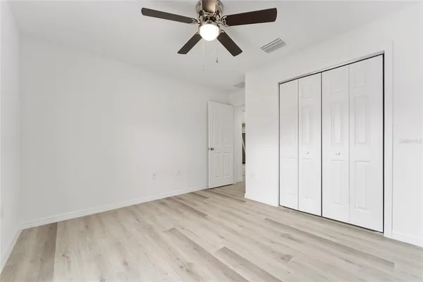 a view of an empty room and chandelier fan